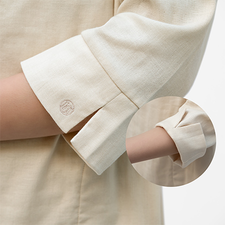 八分袖に「カフス型の袖口」は、折り返しやすい<br>「スリット入り」。 端にはさりげなく「ブランドロゴ刺繍」